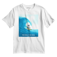 White t-shirt with a graphic of a surfer on a wave and text 'Too Real to be Real'